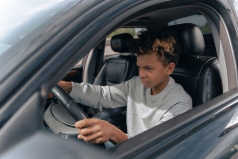 Een jonge bestuurder die zijn autorijbewijs B opleiding volgt met een instructeur in een auto.