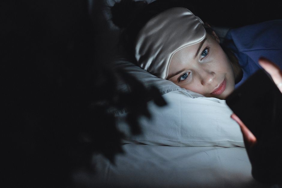 Een ontspannen slaapkamer met slaaphulpmiddelen zoals ergonomische kussens en een verzwaringsdeken voor betere nachtrust.